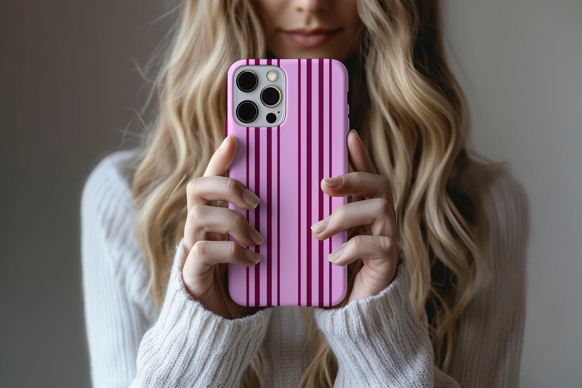 Lifestyle image of Sunday Club phone case showing pink and burgundy vertical stripe print
