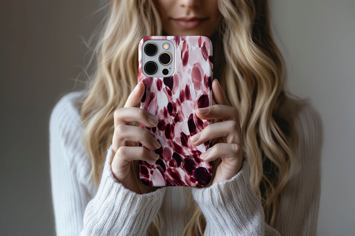Lifestyle image of Confetti (Berry) phone case showing berry, blush pink and cream confetti glass print