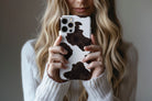 Lifestyle image of Cowhide phone case showing dotty design 