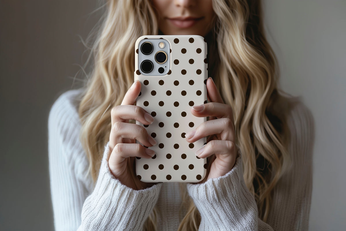 Lifestyle image of Cream Spot phone case showing cream and chocolate brown polka dot print