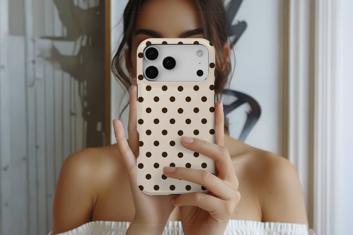 Lifestyle image of Cream Spot MagTough phone case showing cream and chocolate brown polka dot print