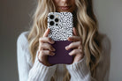 Lifestyle image of Geo Dots (Black Cherry) phone case showing geometric dots print design