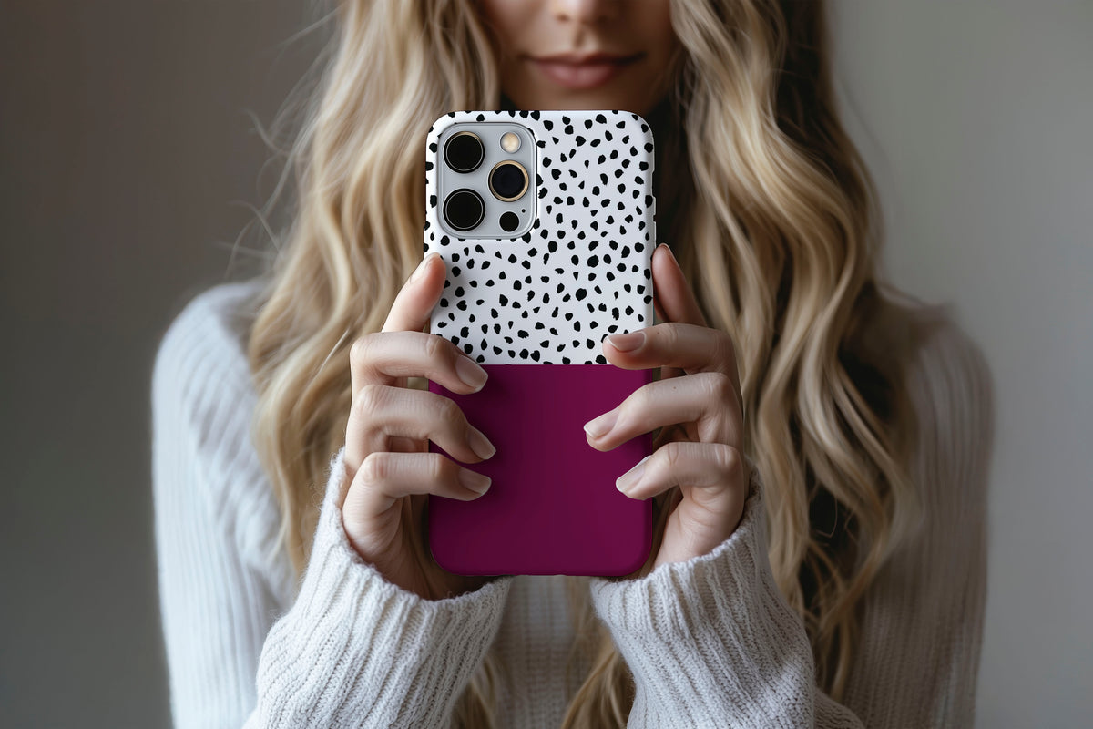 Lifestyle image of Geo Dots (Burgundy) phone case showing black and white irregular dot print with burgundy colour block