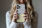 Lifestyle image of Geo Dots (Butter Yellow) phone case showing geometric dots print design