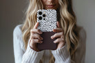 Lifestyle image of Geo Dots (Espresso) phone case showing black and white irregular dot print with espresso brown colour block