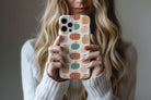 Lifestyle image of Harvest Pop phone case showing pumpkin print design