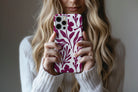 Lifestyle image of Matisse (Burgundy) phone case showing burgundy botanical line print on a cream base