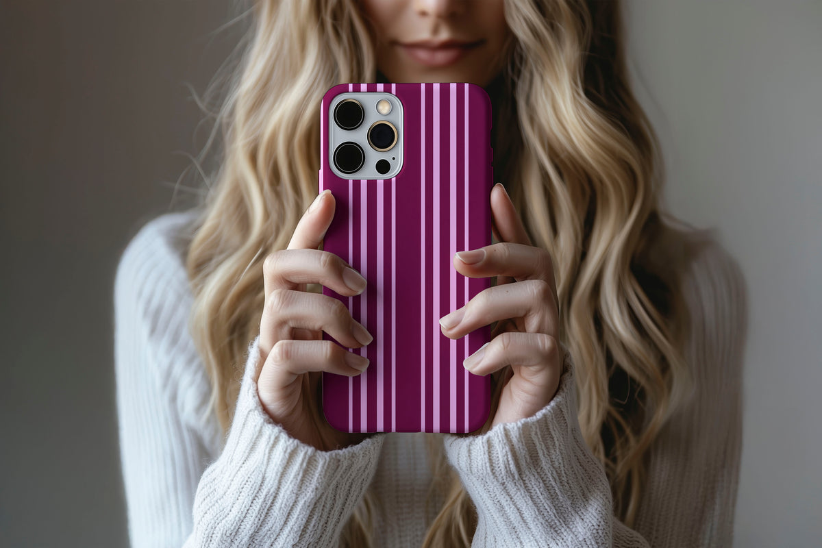 Lifestyle image of Soho phone case showing rich burgundy and pink vertical stripe print