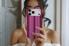 Lifestyle image of Soho MagTough phone case showing rich burgundy and pink vertical stripe print