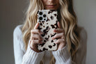 Lifestyle image of Vanilla Shell phone case showing cool cream tortoiseshell-inspired print with deep espresso brown markings