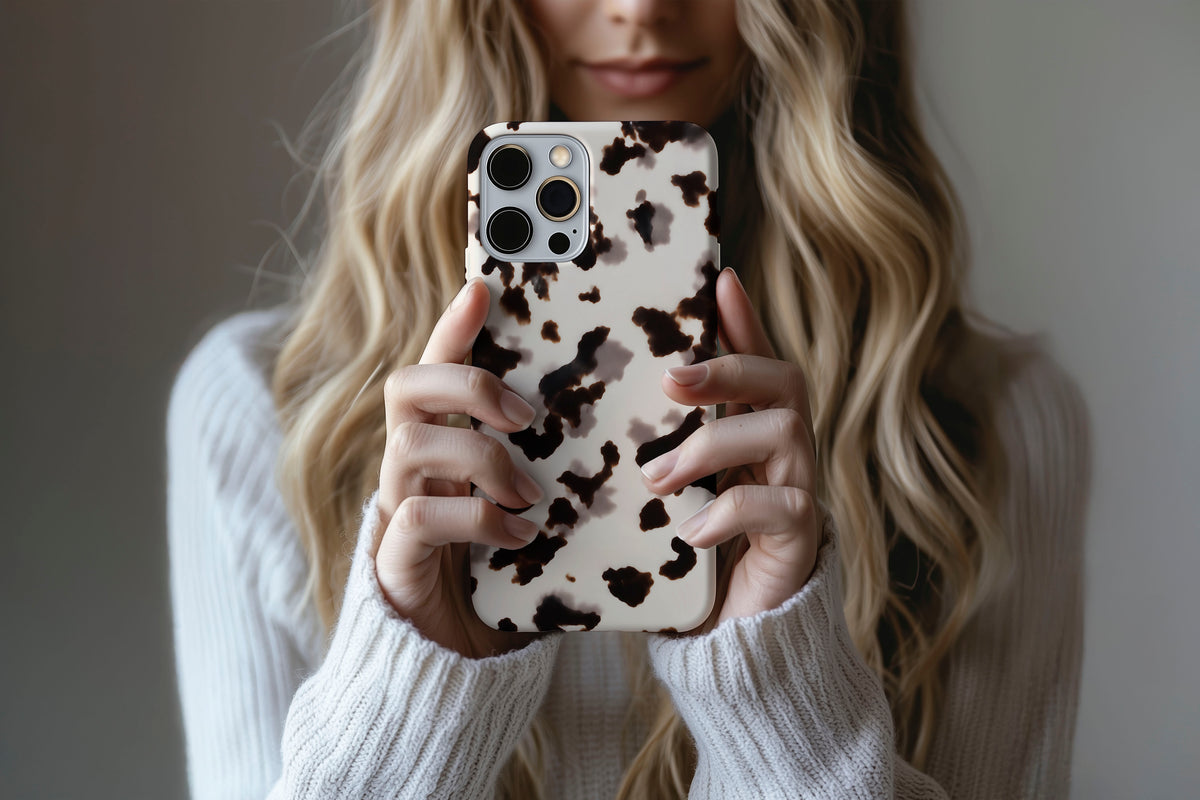 Lifestyle image of Vanilla Shell phone case showing cool cream tortoiseshell-inspired print with deep espresso brown markings